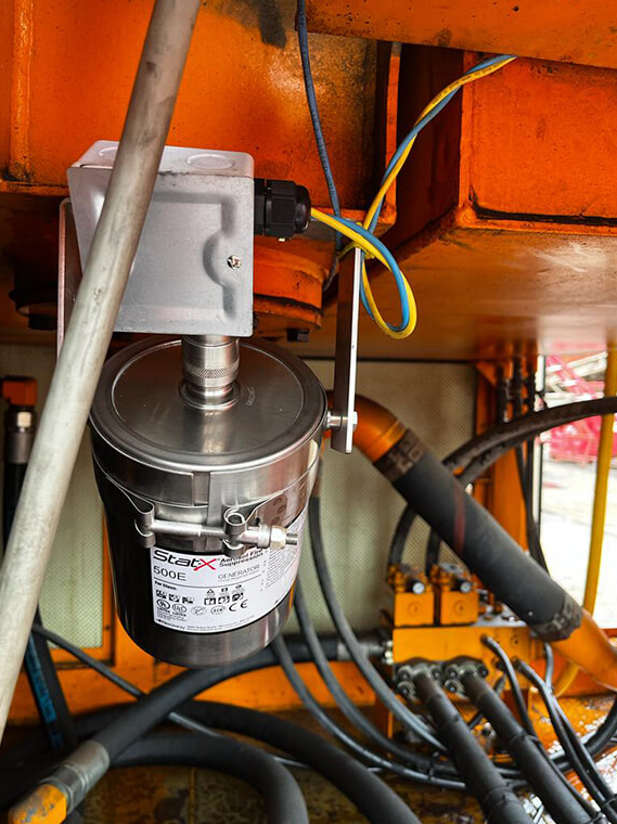 Stat-X 500E Aerosol-Löschgenerator installiert im Maschinenraum eines Gittermast-Krans – Brandschutz für mobile Maschinen